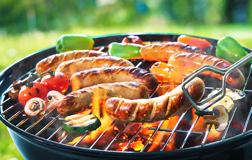 Gluten free sausages and vegetables on a barbecue